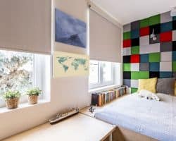 Block-out Roller Blinds in bedroom with large fitted bed and patchwork wall Block-out Roller Blinds